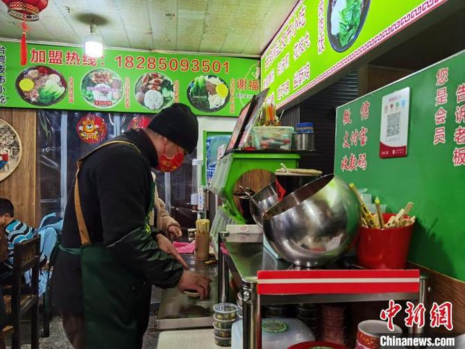 圖為正在店里忙碌的謝木傳。　周燕玲 攝