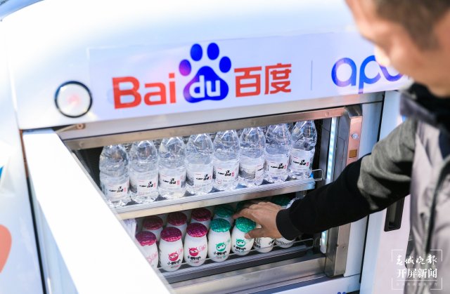 游客在百度智行自動售貨機前掃碼購買商品2.jpg