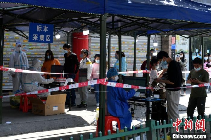 福州市倉山區(qū)蓋山鎮(zhèn)管控區(qū)內(nèi)的居民排隊等待核酸檢測采樣。　呂明 攝