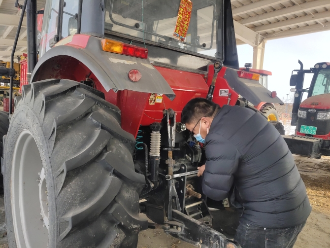 圖為九師一六四團(tuán)的個(gè)體農(nóng)機(jī)戶正在檢修農(nóng)機(jī)（茍匯敏　攝）