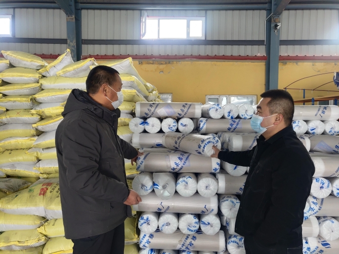 圖為九師一六四團(tuán)的職工正在購(gòu)買地膜和化肥（茍匯敏　攝）