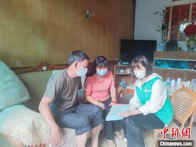 圖為楊玉玲(右一)向社區(qū)居民發(fā)放防疫資料?！±钏刮?攝