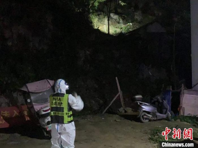 移民管理警察用手電筒照射巡視山坳?！№f德富 攝