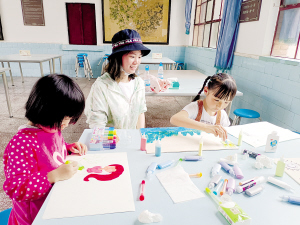 家長(zhǎng)帶孩子畫沙畫。