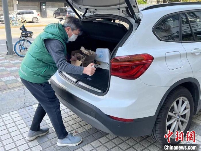 普陀區(qū)長征鎮(zhèn)建二居民區(qū)黨總支書記王榮壽正在給車輛消毒 受訪者供圖