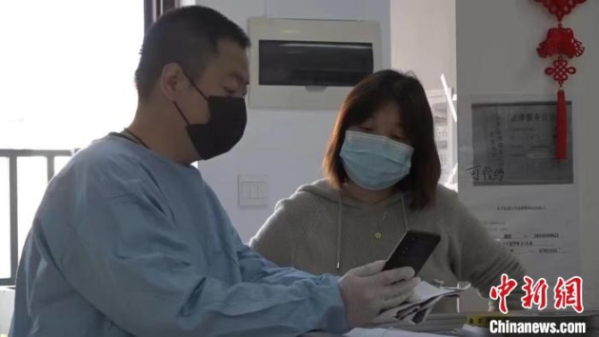 松江區(qū)永豐街道玉榮居民區(qū)黨總支書記葉菊麗(右)正與志愿者溝通小區(qū)發(fā)放物資事宜 受訪者供圖