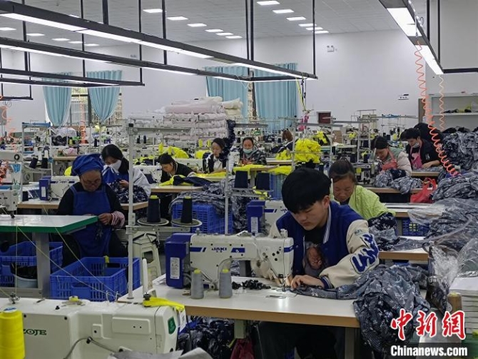 搬遷民眾在制衣工廠工作。　石小杰 攝