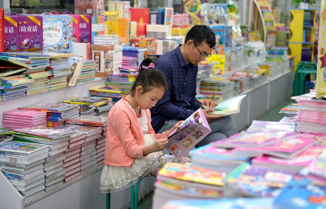 暑期里，家長帶著孩子在書城里看書。本報記者 龍宇丹 實習生 王慶杰 攝