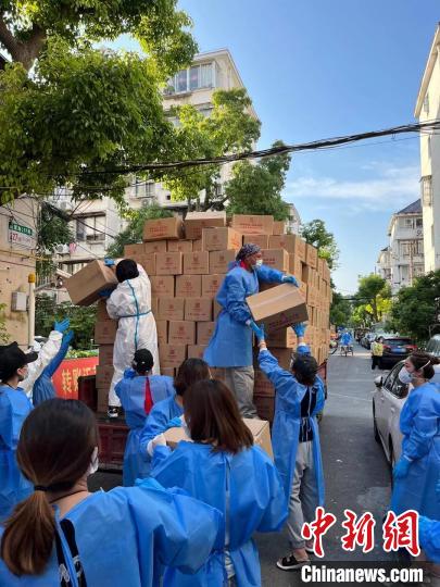 圖為志愿團(tuán)隊(duì)在為居民分發(fā)物資。　受訪者供圖