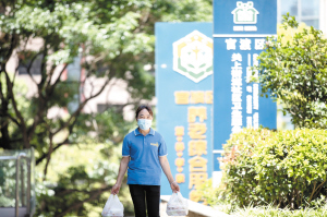 工作人員為行動(dòng)不便的老人送餐上門。記者張曉莉攝