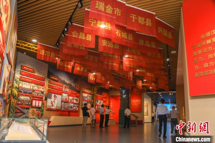 圖為展廳內(nèi)懸掛的印有贛南等原中央蘇區(qū)各縣市區(qū)名字的旗幟?！⒘?攝