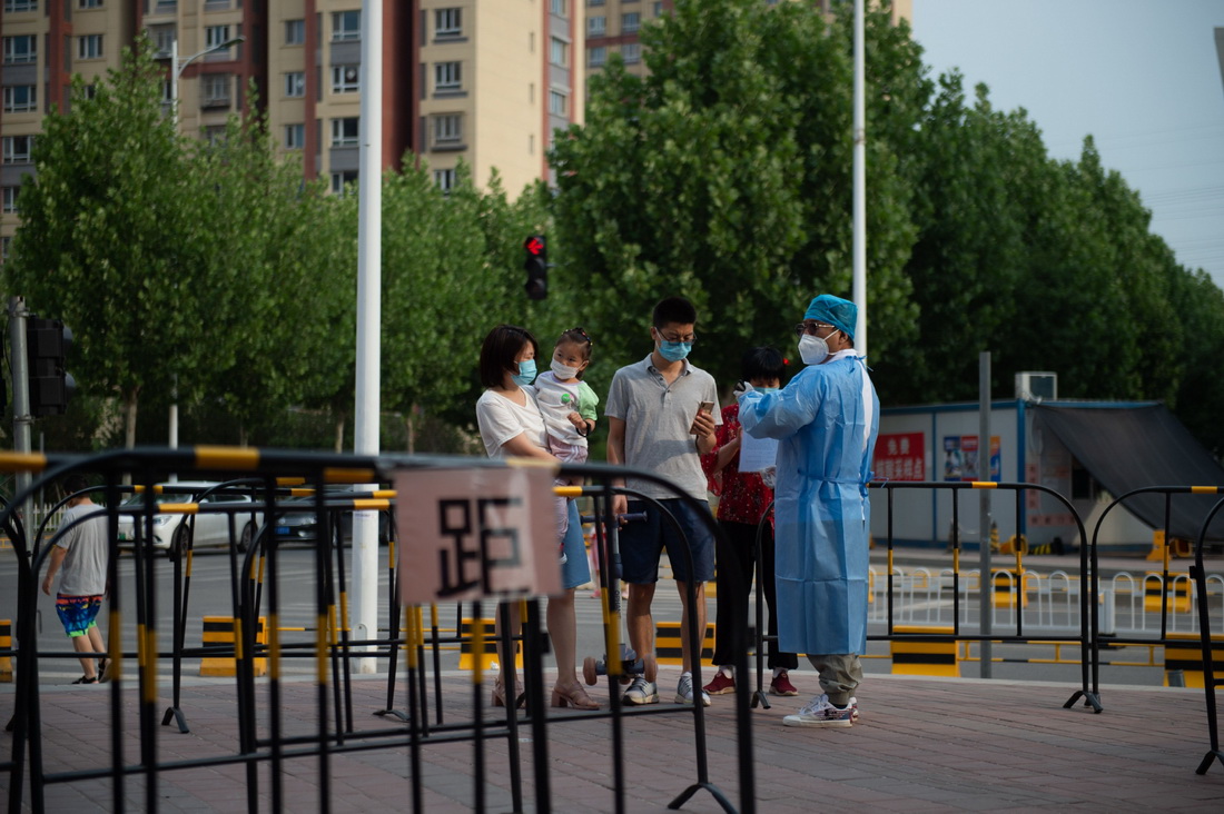6月3日，張旭（右一）引導前來進行核酸采樣的居民掃描北京健康寶。新華社記者 陳鐘昊 攝