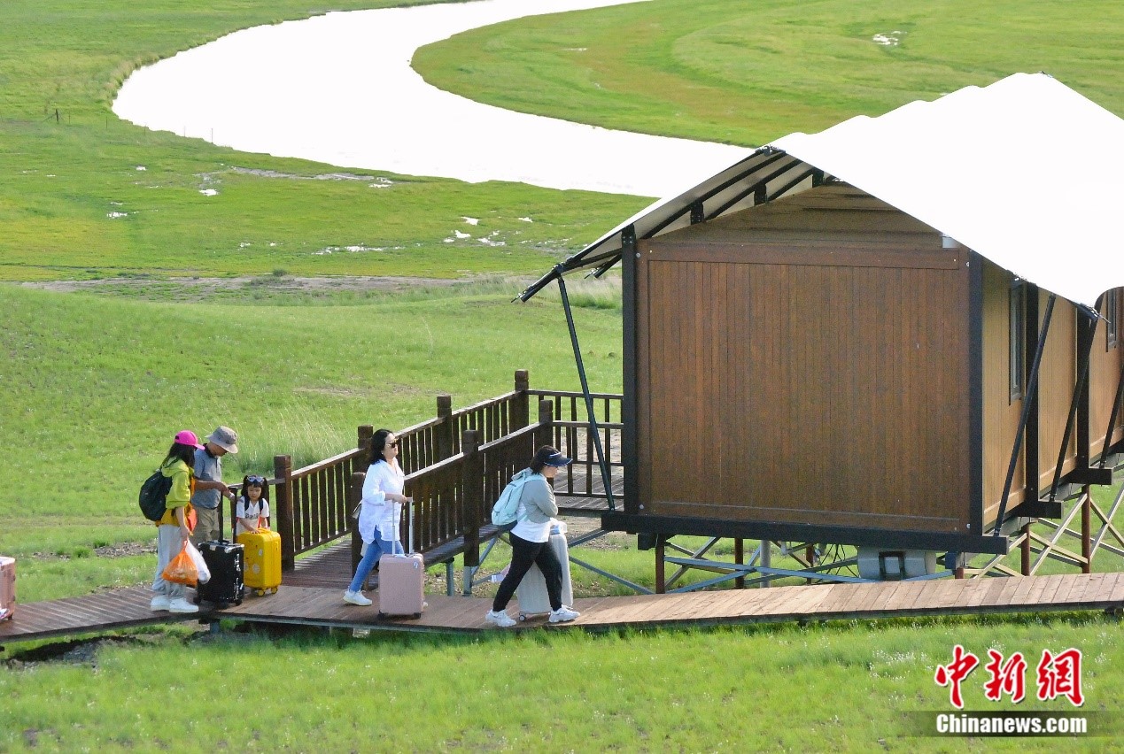 圖為游客正提著行李走進(jìn)呼倫貝爾草原上的蒙古包民宿。蘇亦瑜 攝