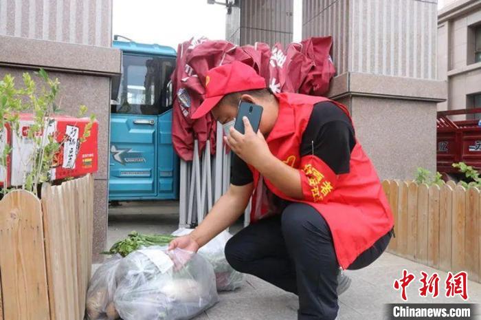 一名志愿者正在為居民配送生活物資。　張馨予 攝