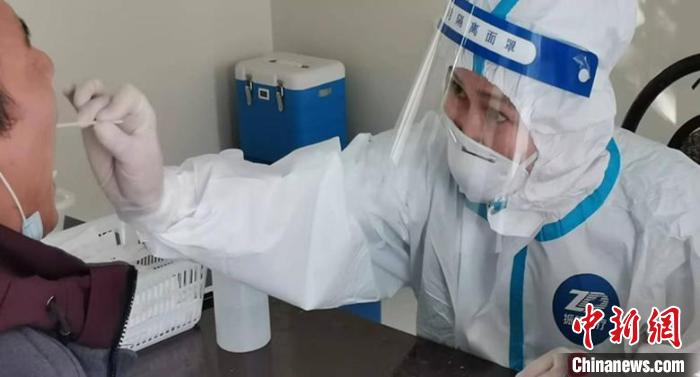 一名醫(yī)務人員專注地為居民做核酸檢測?！「叱?攝