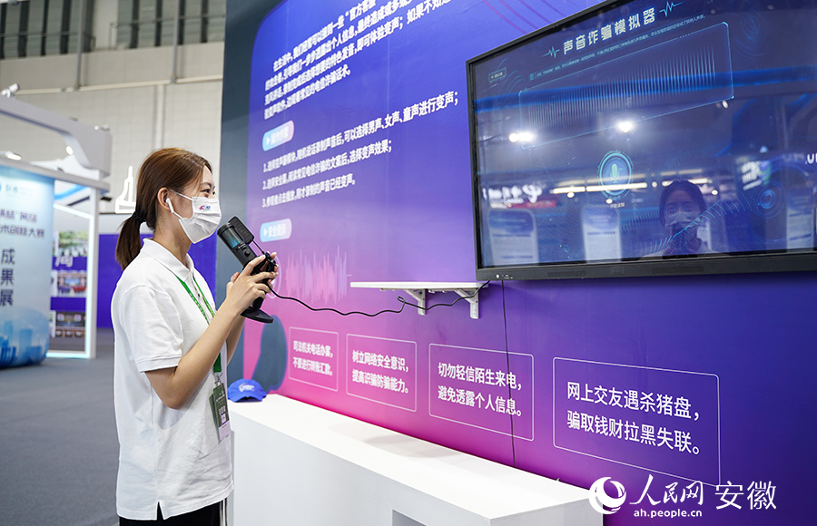 觀眾在展臺(tái)前體驗(yàn)“聲音詐騙模擬器”。人民網(wǎng) 王銳攝