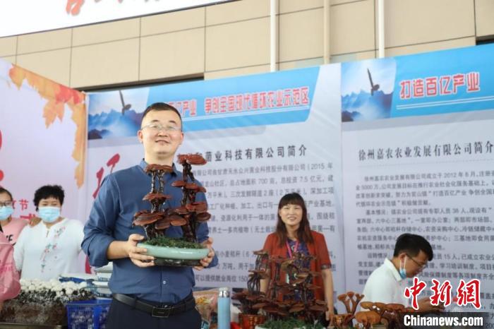 杜健在現(xiàn)場(chǎng)幫種植戶推銷(xiāo)靈芝盆景。　顧士剛 攝