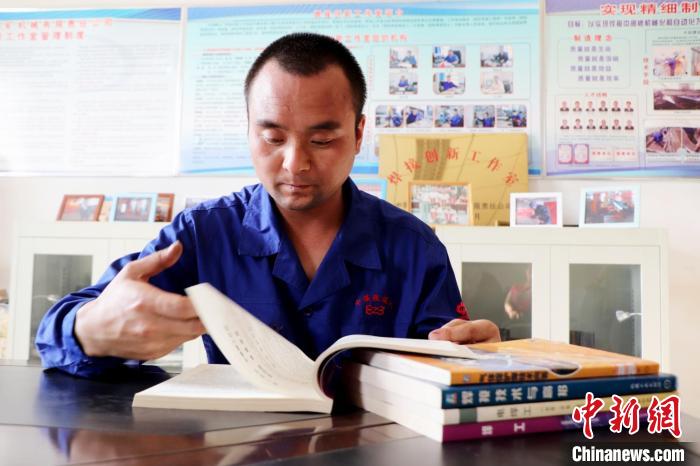 圖為工作之余，閱讀專業(yè)書籍的王萬明。(資料圖) 中煤張家口煤礦機械有限責(zé)任公司供圖
