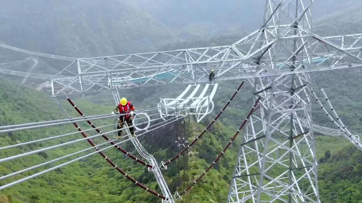 崇山峻嶺間，特戰(zhàn)班成員在高120米、直徑11公分左右的導(dǎo)線上作業(yè)。（圖片由國網(wǎng)山西超高壓輸電公司提供）