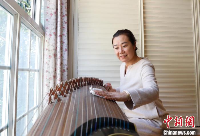 母親李鳳鳴正在擦拭龐鈺千喜歡的古箏?！±铦?攝