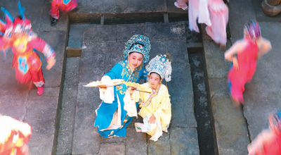 圖為8月9日，在浙江省杭州市臨安區(qū)天目山鎮(zhèn)交口村文化禮堂內(nèi)，戲曲老師在指導(dǎo)小學(xué)生學(xué)習(xí)戲曲表演技藝和經(jīng)典唱段，在豐富“雙減”內(nèi)容的同時(shí)滿(mǎn)足學(xué)生多樣化需求，讓孩子感受傳統(tǒng)文化魅力。胡劍歡攝（人民視覺(jué)）