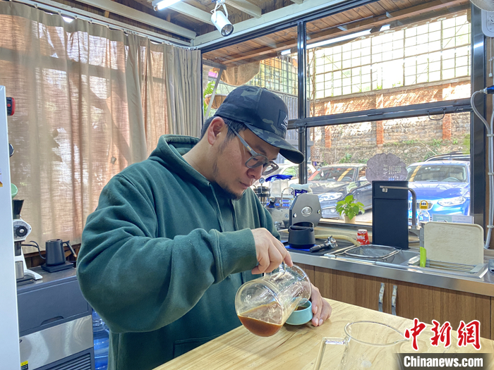 圖為10月21日，劉肇中在咖啡工作室里品嘗剛剛沖好的咖啡。 <a target='_blank' href='/'>中新社</a>記者 陳靜 攝