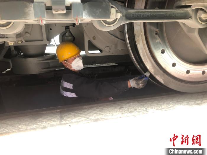 圖為探傷組職工對(duì)機(jī)車輪對(duì)進(jìn)行超聲波探傷?！O義元 攝