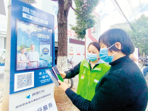 社區(qū)工作人員教老年人掃碼打車。記者劉凱達(dá)攝