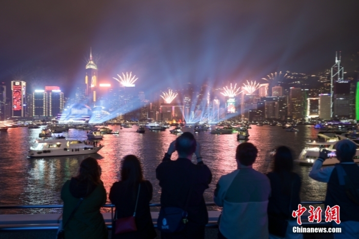 2023年1月1日零時，維多利亞港兩岸燈光璀璨，綻放煙花，香港迎來新的一年。圖為市民在海濱倒數(shù)迎新年。 中新社記者 陳永諾 攝