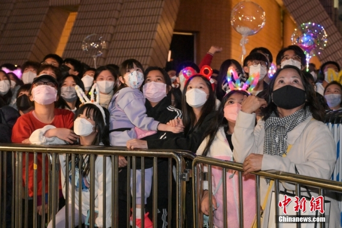 2022年12月31日晚，香港市民在尖沙咀海旁等待倒數(shù)活動，迎接2023年。圖為有香港市民戴上兔耳朵到尖沙咀海旁等待倒數(shù)活動。 中新社記者 陳永諾 攝