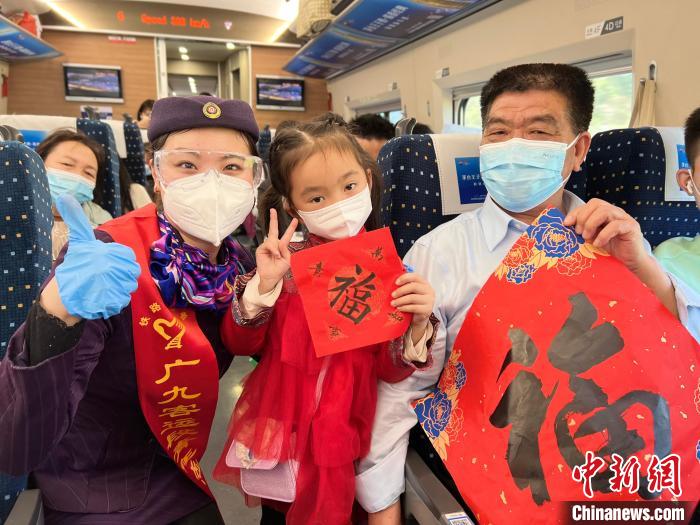 高鐵舉行迎新春聯(lián)歡活動，乘務人員與乘客合影 王鶴然 攝