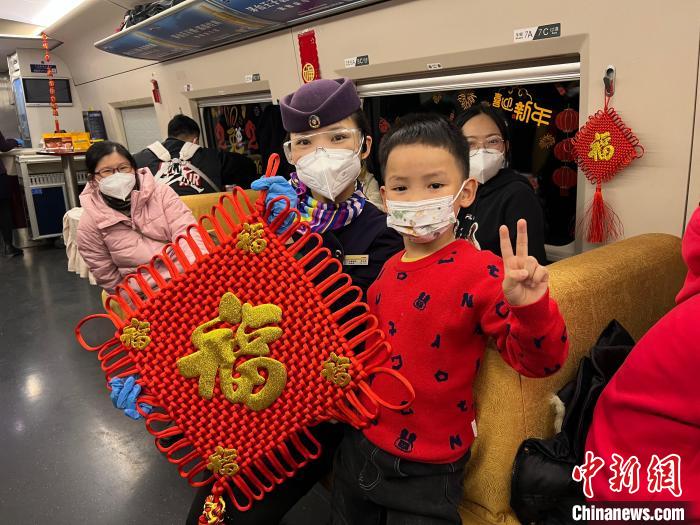 高鐵上舉行迎新春聯(lián)歡活動，乘務人員與乘客合影 王鶴然 攝