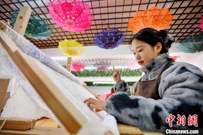 秀工在圖樣上進(jìn)行手工刺繡?！￡愱?攝