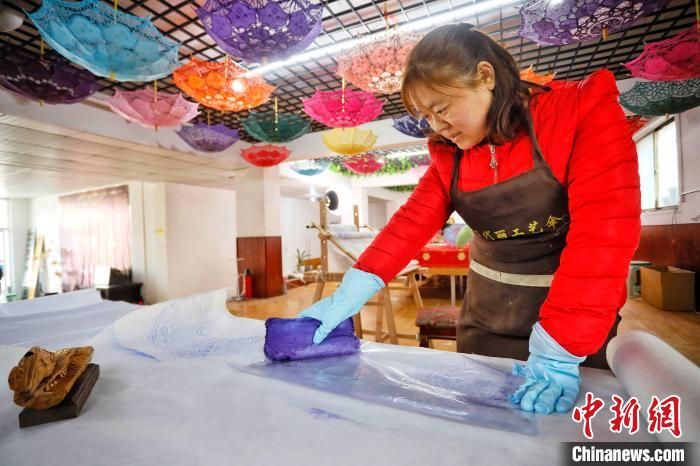 秀工在手工印刷花邊傘圖樣?！￡愱?攝