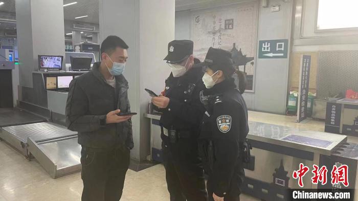 民警劉學(xué)強(qiáng)和李晨俊正在與旅客進(jìn)行交流?！±钚∨?攝