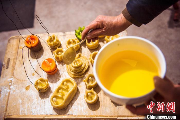 正在往蒸好的面燈內(nèi)加入食用油?！￡惞饨?攝