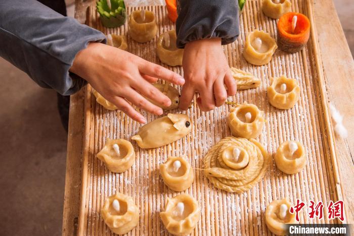 村民在面燈內(nèi)插上燈芯。　陳光金 攝