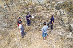 張世山（右三）在梅樹村剖面一處巖石斷層前給中國前寒武系省級地質(zhì)自然保護(hù)區(qū)管護(hù)局的幾個年輕人講解（5月10日攝，無人機照片）