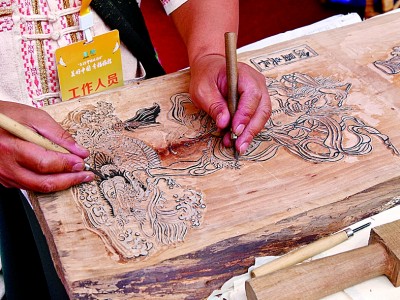 騰沖農(nóng)民畫傳承人賈明安在雕刻甲馬印版。本報(bào)記者 徐鑫雨攝/光明圖片