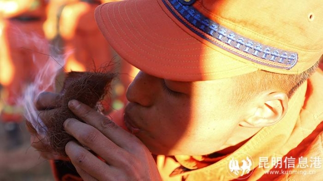 馬繽在野外駐訓期間示范鉆木取火吹燃火星