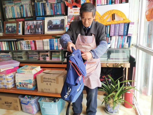 楊人和展示買書時背的背包（采訪傳編輯）他們年過七旬，一身書香！來看看大理兩位“最美閱讀推廣人”的故事…….jpg
