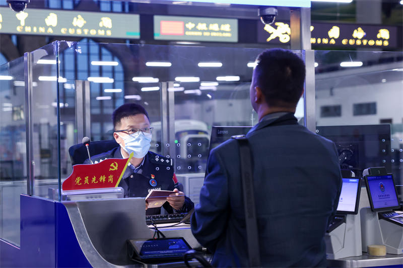 圖為霍爾果斯出入境邊防檢查站民警為入境游客辦理邊檢手續(xù)。宋唯一攝