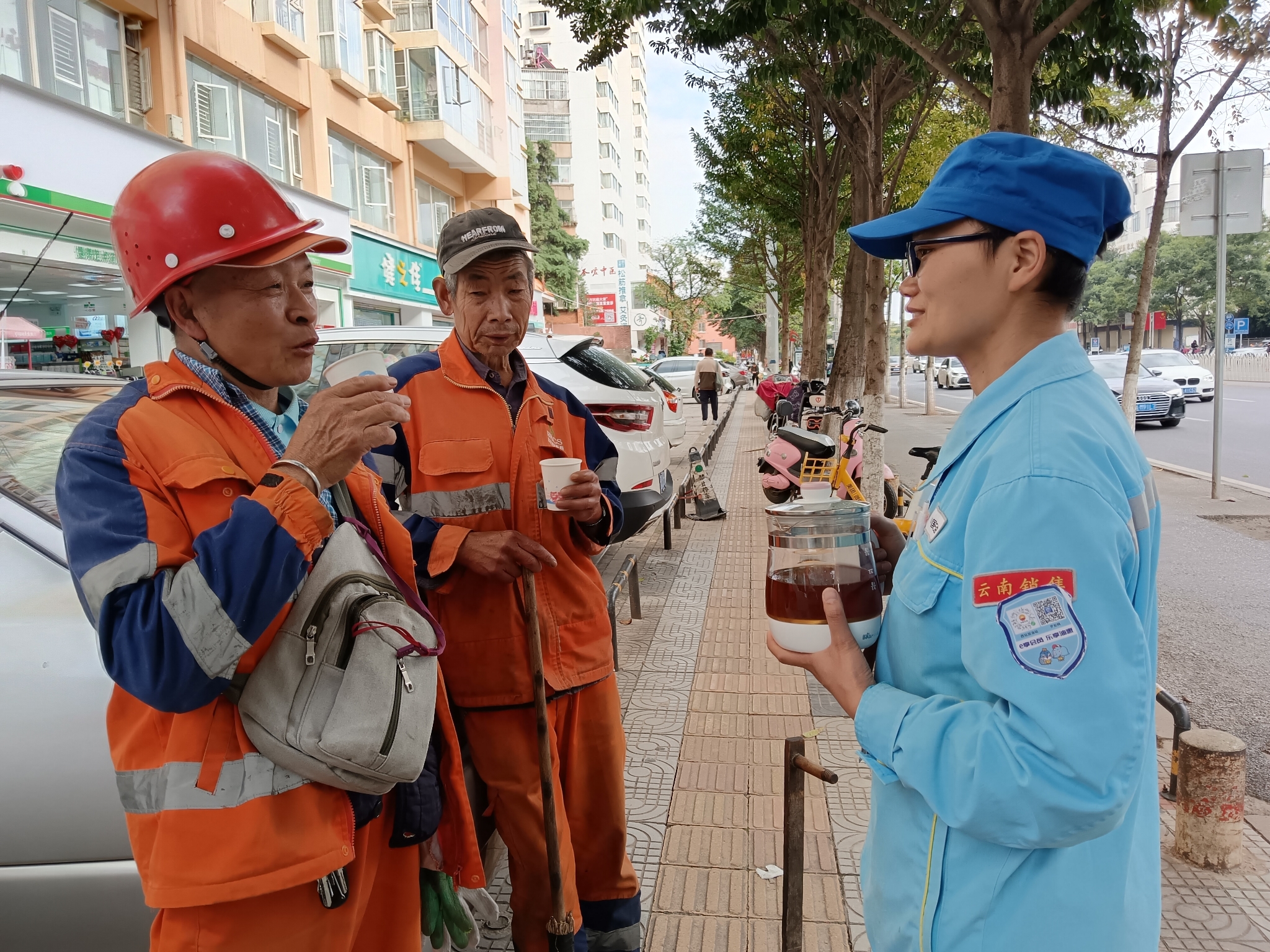 加油站工作人員在街道旁為環(huán)衛(wèi)工人遞上姜茶與他們嘮嗑