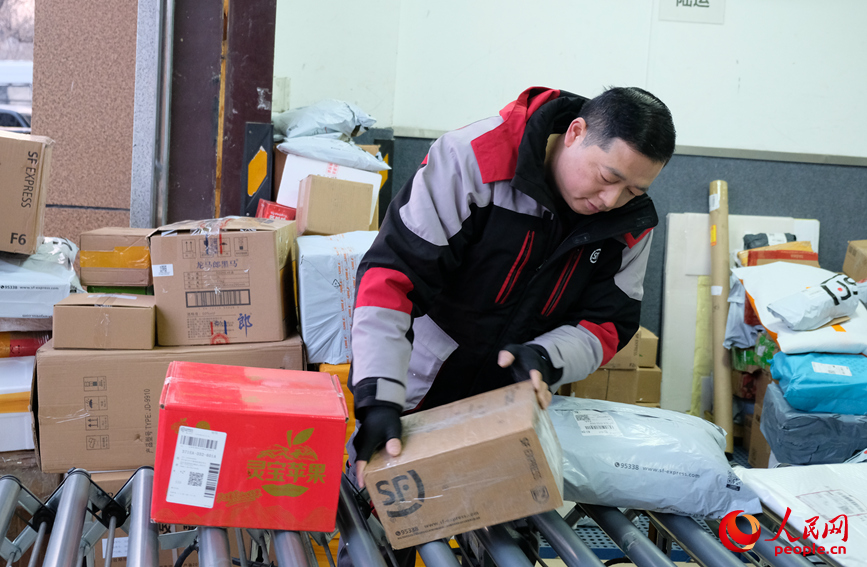 春節(jié)前包裹量攀升，任秀林認(rèn)真分揀、細(xì)致查驗(yàn)，守護(hù)年貨安全。人民網(wǎng)記者 常力元攝