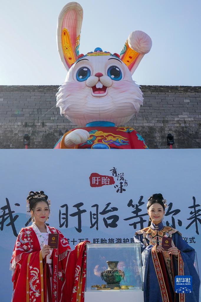 1月10日，在南京老門東歷史街區(qū)，兩名身穿古裝的工作人員在展示“旅游護照”。