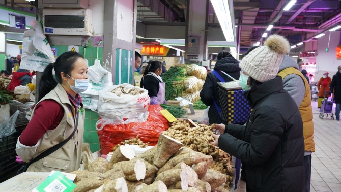 居民在攤位前買菜